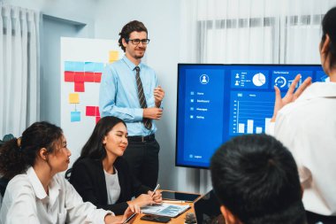 İş adamı, finansal rapor veri analizi veya pazar eğilimi gösterisiyle iş sunumunu şirketin gelecekteki yönetiminde stratejik planlama için büyük bir TV ekranında sundu. Habiliment