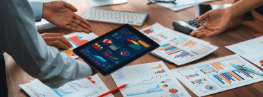 Analist ekibi, masasında tablet olan finansal raporu analiz etmek ve iş görüşü için tablet ekrandaki BI güç göstergesini analiz etmek için BI Fintech 'i kullanıyor. Panorama çekimi. İnceleyin