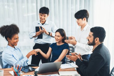 Çeşitli iş arkadaşları başarıyı şirket işyerindeki el sıkışma ve takım çalışmasıyla kutluyor. Çok kültürlü, mutlu profesyonellerden oluşan bir ekip ofiste tokalaşarak birlik oldular. Uyum