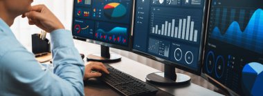 Analizci veri analizi ya da bilgisayar monitöründeki BI gösterge paneli üzerinde çalışıyor. Ticari pazarlama ve strateji planlaması için Fintech 'in şirket ofisindeki finansal verilerini analiz eden bir işadamı. Önde.