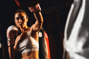 Asyalı kadın Muay Taylandlı boksör boks antrenmanını yumrukluyor idman antrenörüne boks eldiveni takıyor, Muay Tay boks tekniği ve becerisi sergiliyor. Impetus