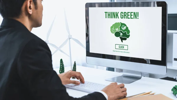 除了企业社会责任的努力外 在办公室工作的商人还利用太阳能电池技术制定环境友好型替代能源的计划或项目 并在电脑屏幕上显示 以创造更绿色的环境 — 图库照片
