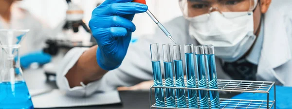 一组专职的科学家在医学实验室进行化学实验 小心地将准确数量的液体从吸盘滴入试管 用于疫苗药物或抗生素的研发 新时代 — 图库照片