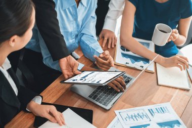 Çok ırklı analist ekibi toplantı masasındaki finansal verileri analiz etmek için BI Fintech yazılımı kullanıyor. Finansal konsol veri ekranında pazarlama göstergesi için analiz edilmiş grafikle birlikte. Uyum