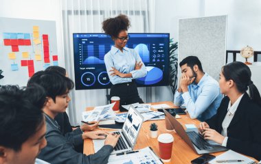 Genç Afrikalı iş kadını modern toplantıda TV ekranında veri analizi paneli sunuyor. Bir grup iş adamıyla konferans odasında iş sunumu. Uyum