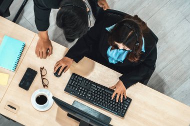 Ofiste bilgisayar başında çalışan, kulaklık takan iş adamları. Jivy