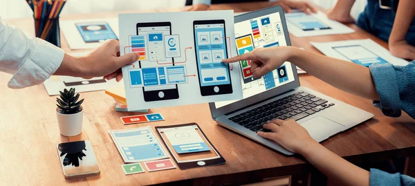 stock image Panorama shot of front-end developer team brainstorming UI and UX designs for mobile app on laptop computer screen. User interface development team planning for user-friendly UI design. Scrutinize