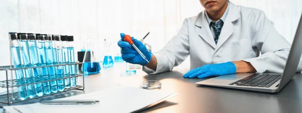 科学者は医学実験室で化学実験を行い 正確な液体をピペットからワクチン薬や抗生物質の開発のための試験管に慎重に落下させる — ストック写真