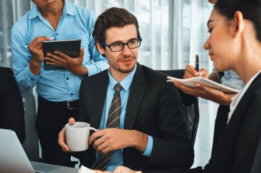 Modern ofis ortamında çalışan çeşitli etnik gruplardan çeşitli iş adamları. Üretken ve çok ırklı ofis çalışanları stratejik ticari pazarlama konusunda tartışmaya giriştiler. Habiliment