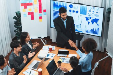 Çeşitli iş arkadaşları bunu şirket işyerinde el sıkışma ve takım çalışmasıyla kutluyor. Başarılı bir toplantıdan sonra el sıkışmayla ya da veri analizi üzerine iş sunumuyla birleşen mutlu iş adamları. Uyum