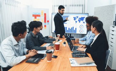 Pazarlama stratejisi için modern toplantıda veri analizi paneli ekranında sunan bir işadamı. Bir grup iş adamıyla konferans odasında iş sunumu. Uyum