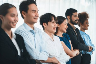 Mutlu ve gülümseyen çok ırklı ofis çalışanı, sinerjiyi ve ticari başarı için işbirliğini destekleyen bir kuyrukta el ele tutuşuyor. Modern işyerinde çeşitli profesyonel ofis çalışanları arasında bağ var. Uyum