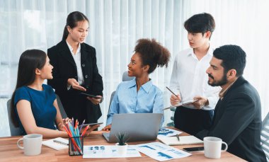 Çok ırklı analist ekibi toplantı masasındaki mali raporu analiz etmek için BI gösterge tablosunu kullanıyor. Çeşitli iş adamlarından oluşan bir grup, FIntech 'in veri analizini başarılı iş pazarlaması için kullanır. Uyum