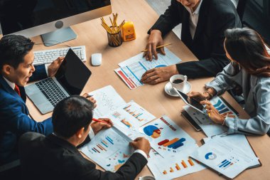 İş adamları grup toplantısı ofiste yukarıdan çekildi. İş kadınları, iş adamları ve ofis çalışanları toplantı masasında proje planlama belgeleriyle takım konferansında çalışıyorlar. Jivy