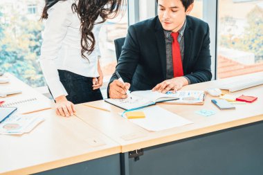 İki iş adamı toplantı odasında proje stratejisi hakkında konuşuyor. İş adamı, iş yerinde iş arkadaşlarıyla proje planlamasını tartışırken aynı zamanda mali raporla ilgili sohbet ve tavsiyelerde bulunuyor. Jivy