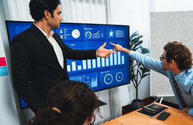 İş adamı, finansal rapor veri analizi veya pazar eğilimi gösterisiyle iş sunumunu şirketin gelecekteki yönetiminde stratejik planlama için büyük bir TV ekranında sundu. Habiliment