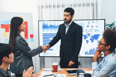 Çeşitli iş arkadaşları bunu şirket işyerinde el sıkışma ve takım çalışmasıyla kutluyor. Başarılı bir toplantıdan sonra el sıkışmayla ya da veri analizi üzerine iş sunumuyla birleşen mutlu iş adamları. Uyum