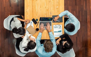 Panorama üst düzey iş analist grubu toplantı masasındaki finansal veri raporunu analiz ediyor. İş zekası analizine göre çizelge ve grafik paneli. Çok titiz.