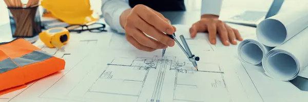 Architect or engineer working on building blueprint, contractor designing and drawing blueprint layout for building construction project. Civil engineer and architectural design concept. Insight
