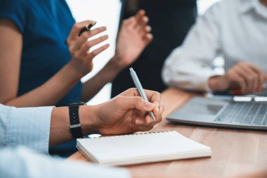 Sekreter, toplantı odasında görüşen bir grup çok ırklı iş adamıyla şirket toplantısında defterine not alıyor. Modern ofiste profesyonel toplantılarda çeşitlilik. Uyum