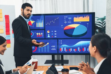 Pazarlama stratejisi için modern toplantıda veri analizi paneli ekranında sunan bir işadamı. Bir grup iş adamıyla konferans odasında iş sunumu. Uyum