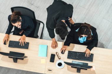 Ofiste bilgisayar başında çalışan, kulaklık takan iş adamları. Jivy