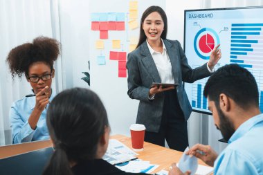 Genç Asyalı iş kadını modern toplantıda TV ekranında veri analizi paneli sunuyor. Bir grup iş adamıyla konferans odasında iş sunumu. Uyum