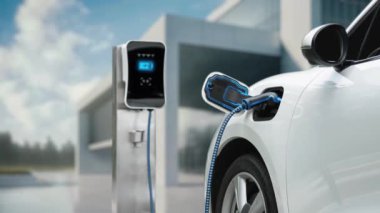 Modern ve fütüristik bina arka planında akıllı EV şarj istasyonundan elektrikli araba şarj oluyor. Alternatif ve sürdürülebilir enerji kullanan şarj edilebilir EV arabaların teknolojik gelişimi. İnceleyin