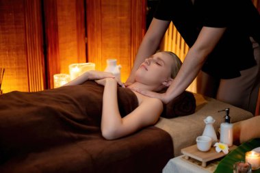 Beyaz kadın müşteri stres önleyici spa masajının keyfini çıkarıyor ve lüks otel ya da otelde sıcak mum ışığında güzellik teniyle eğleniyor. Sessiz.