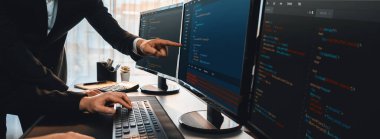 Yazılım geliştirme ekibi ofiste birlikte çalışıyor, bilgisayar ekranında betik görüntülemesi kodluyor. Teknoloji geliştirici şirketinde çalışan programcı ve yazılım mühendisi. Önde.