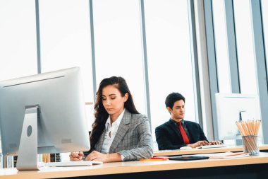 Modern ofis odasındaki masada çalışan iş adamları mali veri raporlarını incelerken. Jivy