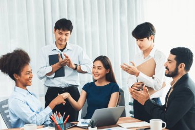 Çeşitli iş arkadaşları başarıyı şirket işyerindeki el sıkışma ve takım çalışmasıyla kutluyor. Çok kültürlü, mutlu profesyonellerden oluşan bir ekip ofiste tokalaşarak birlik oldular. Uyum