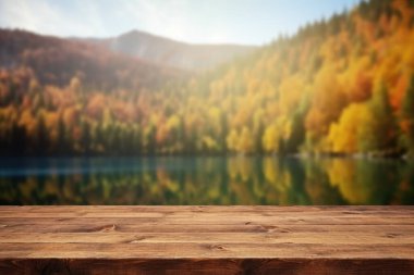 Sonbaharda gölün ve dağın arka planının bulanık olduğu boş ahşap masa. Coşkulu resim.