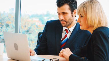 İki iş adamı toplantı odasında proje stratejisi hakkında konuşuyor. İş adamı, iş yerinde iş arkadaşlarıyla proje planlamasını tartışırken aynı zamanda mali raporla ilgili sohbet ve tavsiyelerde bulunuyor. Jivy