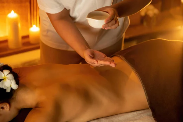 Masseur hands pouring aroma oil on woman back. Masseuse prepare oil massage procedure for customer at spa salon in luxury resort. Aroma oil body massage therapy concept. Quiescent