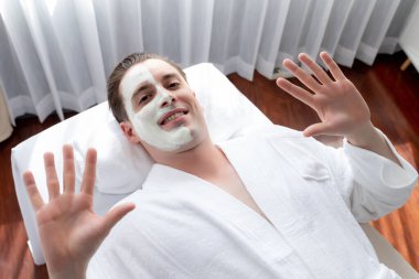 Kaplıca salonunun sakin atmosferi, insan müşterisi modern gün ışığında lüks yüz kremi masajıyla kendini yenileme zevkine kapılıyor. Yüz bakımı ve güzellik konsepti. Sessiz.