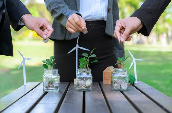 商界人士将省钱的玻璃瓶放在户外桌子上 作为可持续的货币增长投资或生态补贴 绿色企业促进和投资于环境意识 — 图库照片