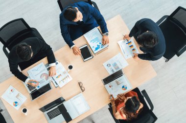 İş adamları grup toplantısı ofiste yukarıdan çekildi. İş kadınları, iş adamları ve ofis çalışanları toplantı masasında proje planlama belgeleriyle takım konferansında çalışıyorlar. Jivy