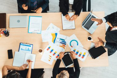 İş adamları grup toplantısı ofiste yukarıdan çekildi. İş kadınları, iş adamları ve ofis çalışanları toplantı masasında proje planlama belgeleriyle takım konferansında çalışıyorlar. Jivy
