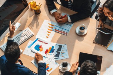 İş adamları grup toplantısı ofiste yukarıdan çekildi. İş kadınları, iş adamları ve ofis çalışanları toplantı masasında proje planlama belgeleriyle takım konferansında çalışıyorlar. Jivy