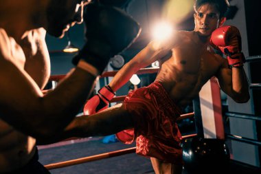 Asyalı ve Kafkasyalı Muay Thai boksörü vahşi boks maçında tekme sallıyor. Güçlü kaslı Taylandlı boksör acımasız dövüş hünerleriyle yumruk ve tekme tokuşturuyor. Impetus