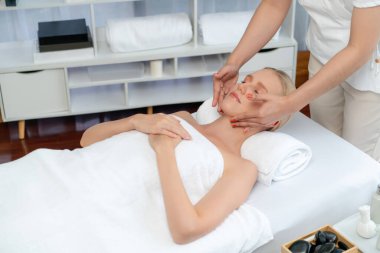 Kafkasyalı kadın stres önleyici kafa masajından ve lüks tatil beldesi ya da otel spa salonundaki modern ışık ortamında yüz güzelliği eğlencelerini şımartmaktan hoşlanıyor. Sessiz.