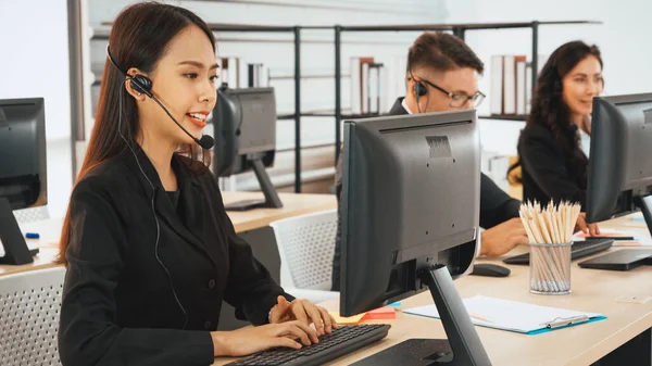 Business people wearing headset working in office to support remote customer or colleague. Call center, telemarketing, customer support agent provide service on telephone video conference call. Jivy