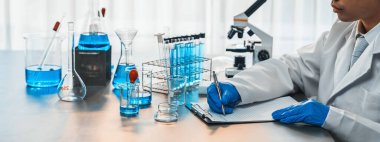 Aşı ilacı ya da antibiyotik için tıbbi laboratuvarda kimyasal deney yaptıktan sonra elde kaydedilen veriler yakından inceleniyor. Bilimsel kimya laboratuvarı ve tıp araştırma konsepti. Neoterik