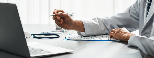 Врач внимательно просмотрите подробное медицинское заключение с ноутбуком и диагностики заболеваний для эффективного плана лечения пациента в кабинете врача. Профессиональная медицинская оценка. Неотвратимость