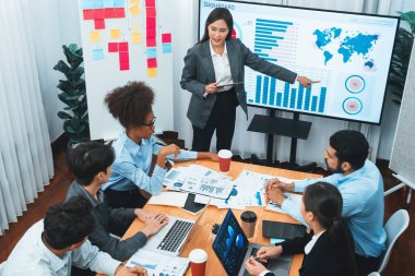 Modern toplantı odasındaki TV ekranında veri analizi paneliyle üst görünüm iş sunumu. İş adamlarının iş pazarlama stratejisini planlamak için beyin fırtınası yapması ya da birlikte çalışması. Uyum