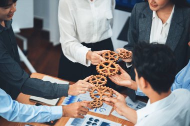 Ofis çalışanı çarkları birlik ve sistem takım çalışması olarak tutuyor. Şirket işyerinde, bir yığın iş kağıdı ve mali raporla toplantı masasında. Ticari başarıları olan iş adamları. Uyum