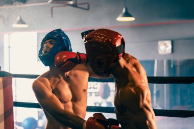 Kasklı iki atletik ve kaslı vücut boksörü ya da boks baş muhafızı vahşi bir boks maçında karşı karşıya. Boks dövüşçüsü boks ringinde dövüşüyor. Impetus