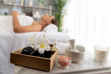 Aromaterapi masajı gündüz atmosferinde ya da spa salonunda bulanık bir kadına odak dekor ve spa aksesuarları kurarak tatil köyünde ya da otel arka planında keyifli aroma spa masajı yapan bir masaj. Sessiz.