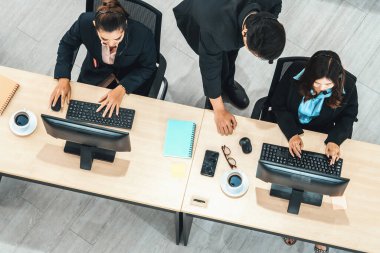 Ofiste bilgisayar başında çalışan, kulaklık takan iş adamları. Jivy